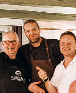 Küchenchef Eike und Servicechef Georgie (r.) unterstützen Sommelier Detlev (l.) bei seinen spannenden Weinabenden im Dorfkrug Volksdorf.